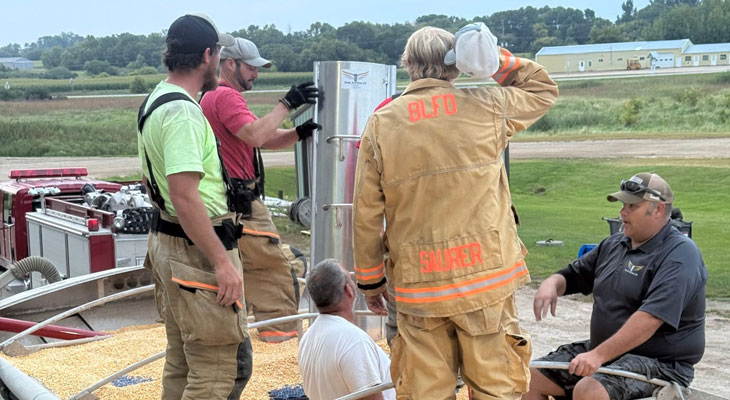 Group of firemen in grain truck with rescue gear