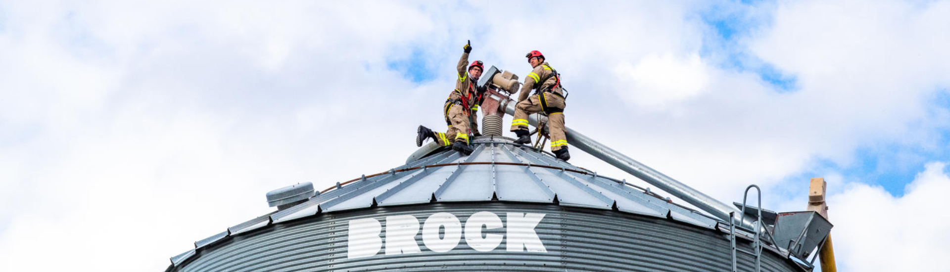Two firemen on top of a grain bin