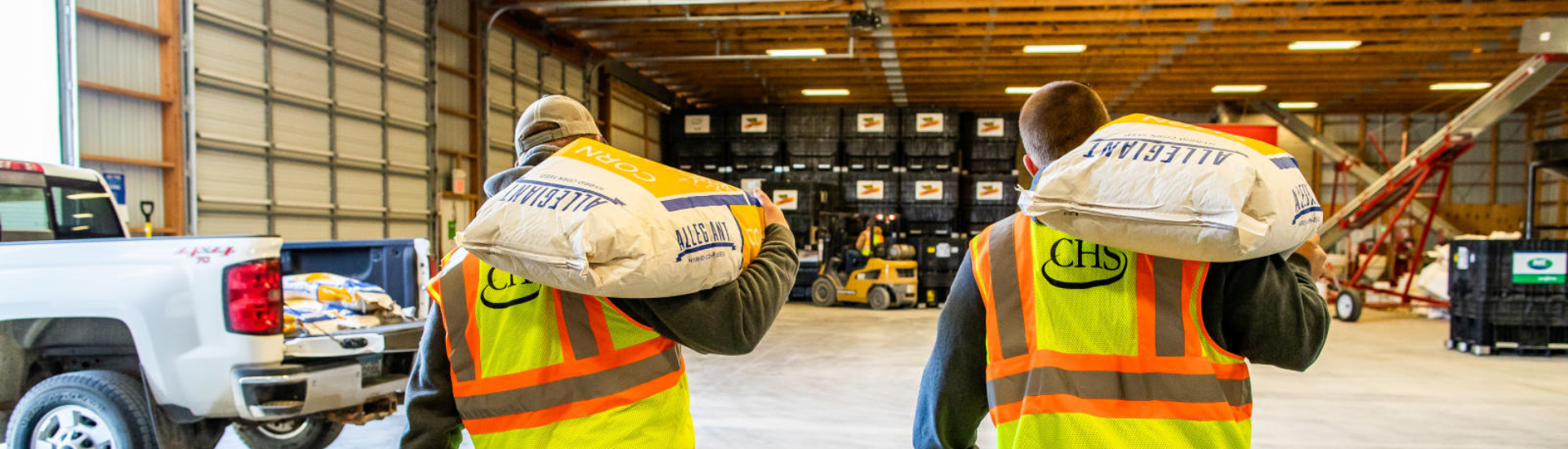 Two men carrying Allegiant seed bags